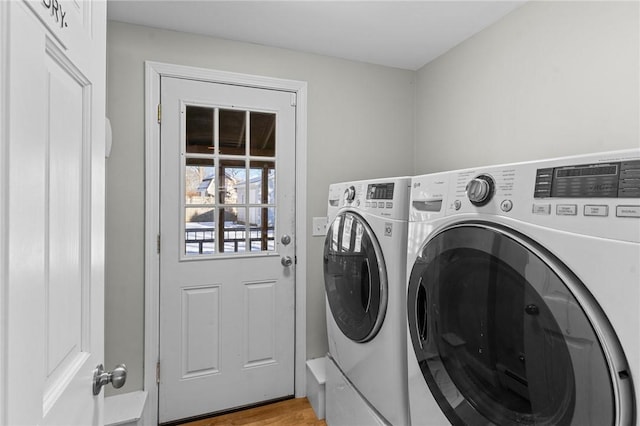 washroom with light hardwood / wood-style floors and washer and dryer