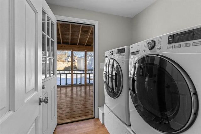 laundry room with independent washer and dryer and light wood-type flooring