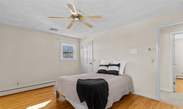 bedroom featuring a baseboard radiator, ceiling fan, and light hardwood / wood-style floors