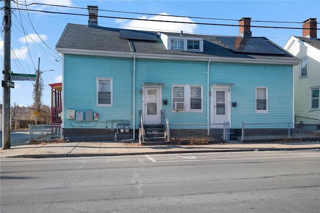 view of front of house featuring cooling unit and solar panels