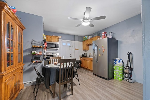 dining room with ceiling fan and light wood-type flooring