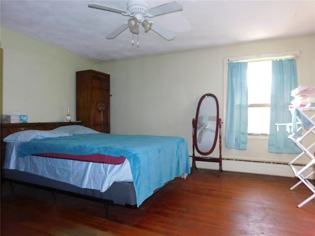 bedroom with dark hardwood / wood-style flooring, baseboard heating, and ceiling fan