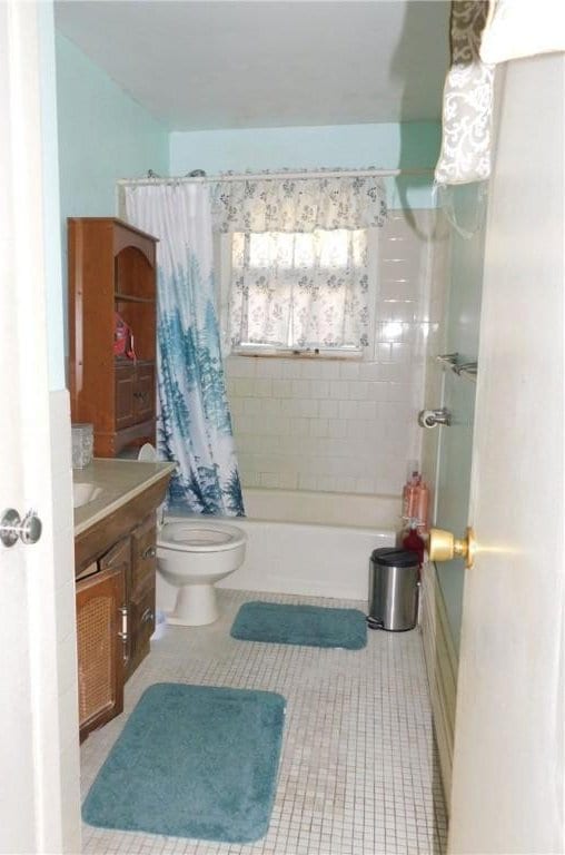 full bathroom with toilet, tile patterned flooring, shower / bath combination with curtain, and vanity