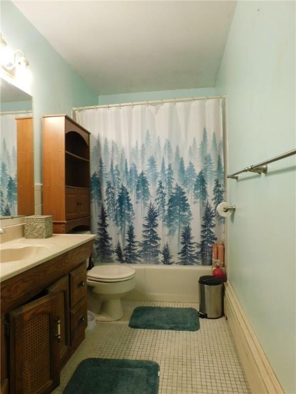 full bathroom with tile patterned floors, shower / bath combo with shower curtain, vanity, and toilet