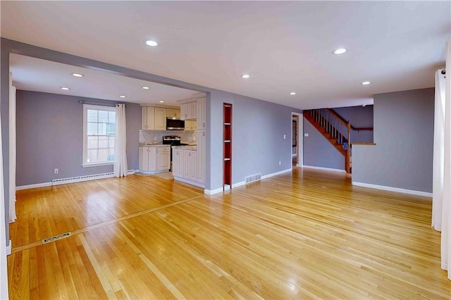 unfurnished living room featuring a baseboard radiator and light wood-type flooring