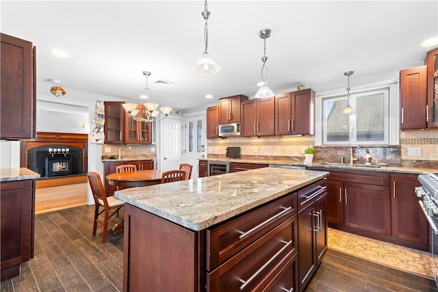 kitchen with decorative light fixtures, sink, tasteful backsplash, and a center island