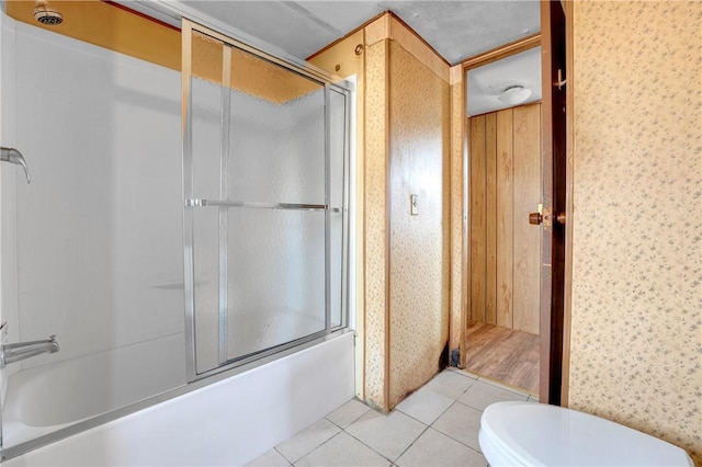 bathroom featuring enclosed tub / shower combo, tile patterned flooring, and toilet