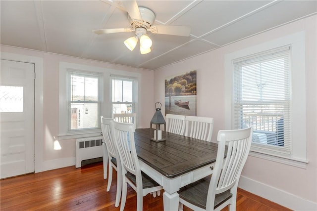 dining space with radiator, hardwood / wood-style floors, and a wealth of natural light