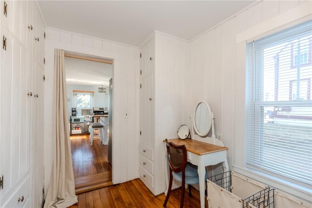 home office with wood walls, crown molding, and hardwood / wood-style floors