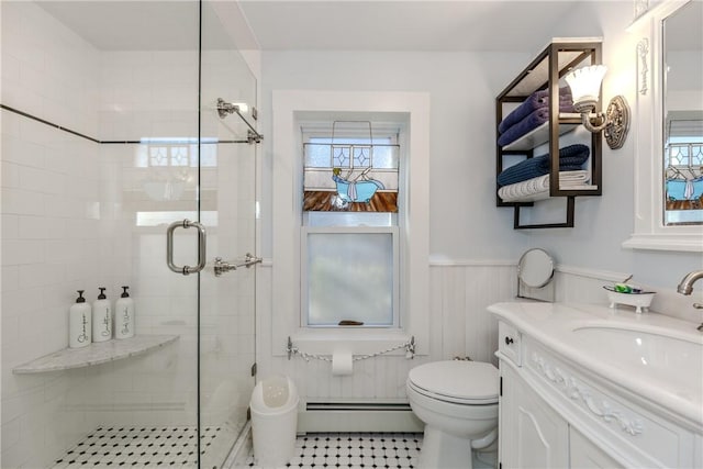 bathroom with baseboard heating, toilet, vanity, a shower with door, and plenty of natural light