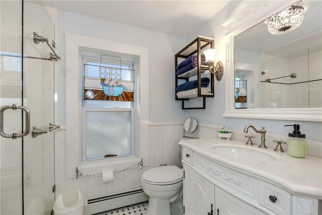 bathroom with toilet, baseboard heating, an inviting chandelier, a shower with shower door, and vanity