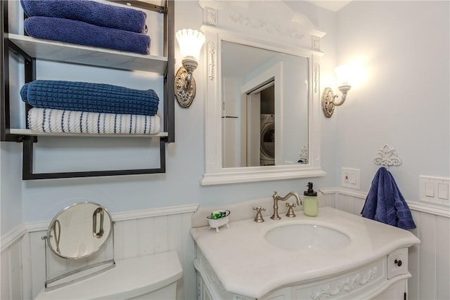 bathroom featuring washer / dryer, vanity, and toilet