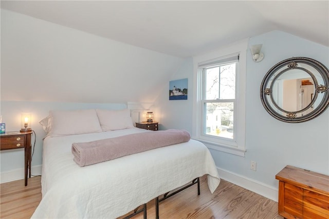 bedroom with lofted ceiling and light hardwood / wood-style floors