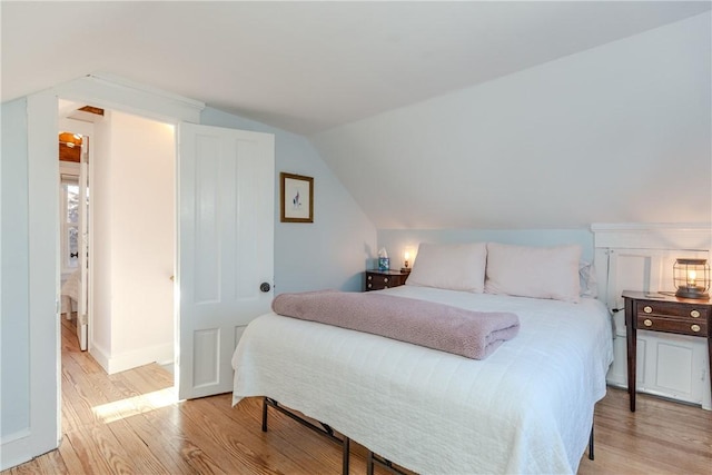 bedroom with light hardwood / wood-style floors and vaulted ceiling