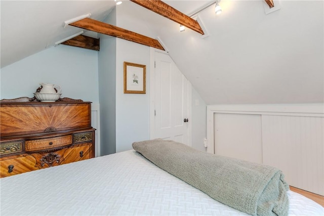 bedroom with a closet and vaulted ceiling with beams