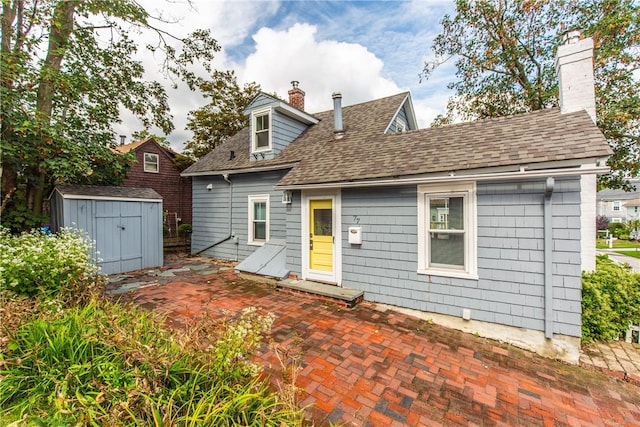 view of front of house featuring a patio area and a storage shed