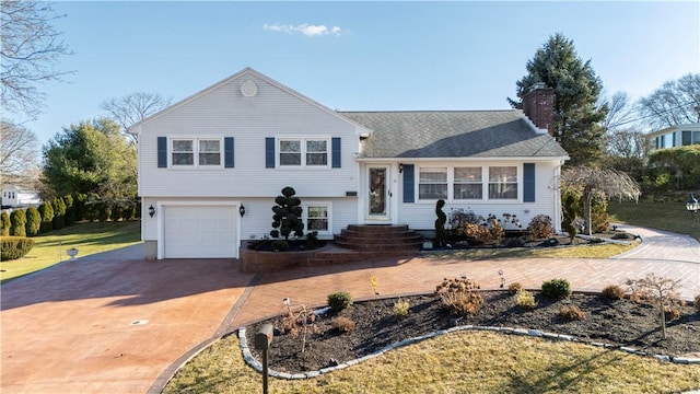 tri-level home featuring a garage and a front lawn