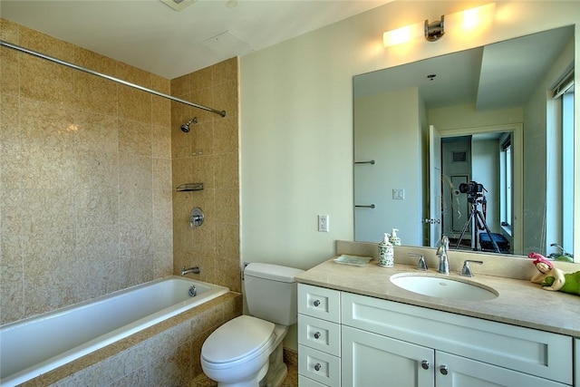 full bathroom with toilet, vanity, and tiled shower / bath