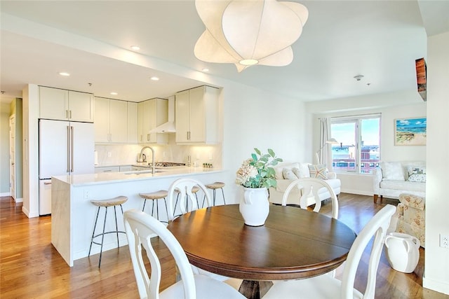 dining space with light hardwood / wood-style floors and sink