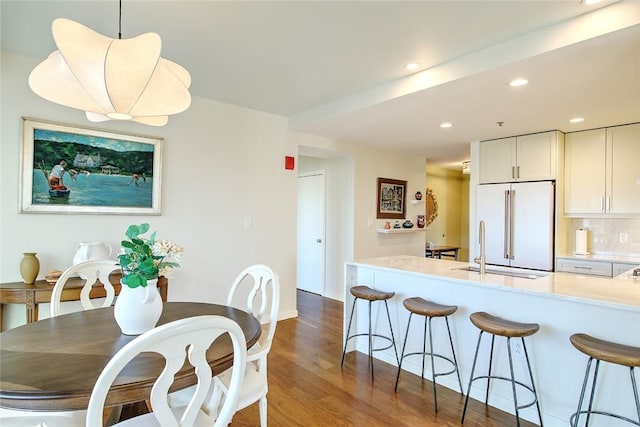 kitchen with sink, decorative light fixtures, white cabinetry, tasteful backsplash, and high end refrigerator