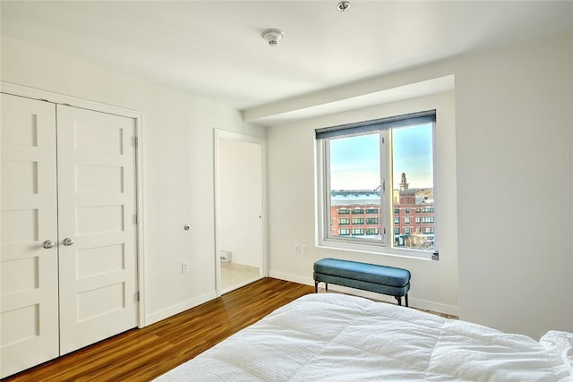 bedroom with dark wood-type flooring and a closet