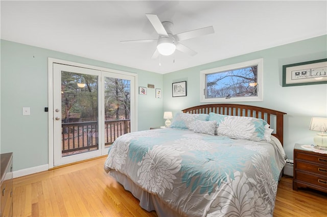 bedroom featuring a baseboard heating unit, ceiling fan, light hardwood / wood-style floors, and access to exterior