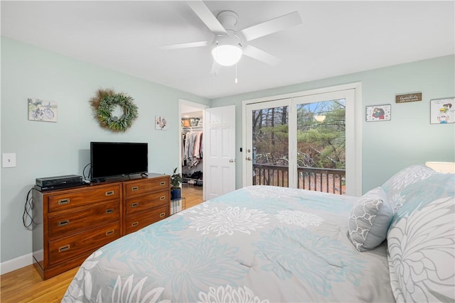 bedroom featuring access to outside, light hardwood / wood-style flooring, a closet, a walk in closet, and ceiling fan