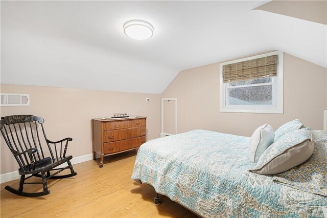 bedroom with vaulted ceiling and light hardwood / wood-style floors