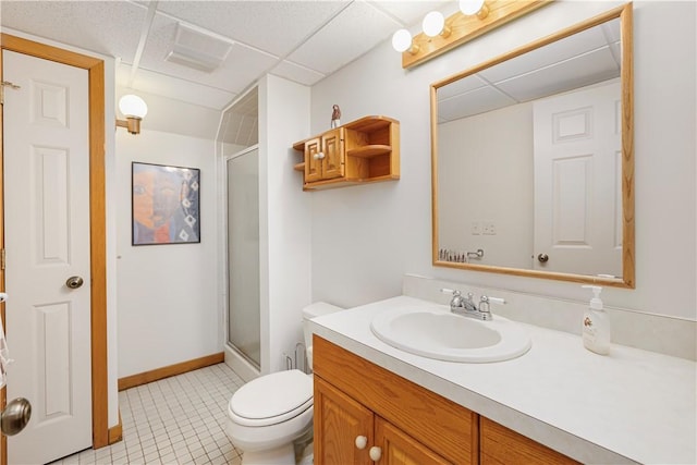 bathroom featuring toilet, a shower with door, a paneled ceiling, and vanity