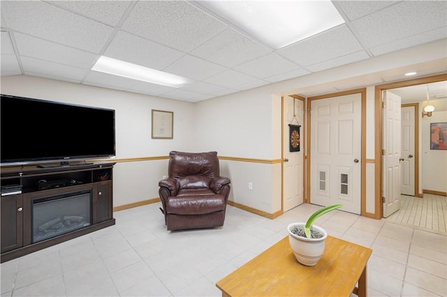 living room featuring light tile patterned floors and a drop ceiling