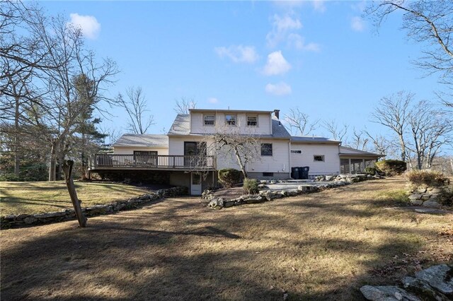 back of property with a yard and a wooden deck