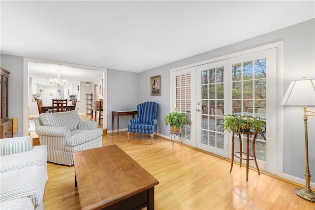 living room featuring french doors, an inviting chandelier, and wood-type flooring