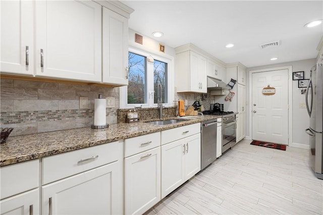 kitchen featuring sink, white cabinetry, appliances with stainless steel finishes, and light stone countertops