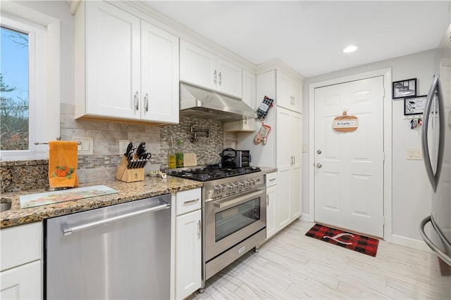 kitchen featuring light stone countertops, white cabinets, and appliances with stainless steel finishes