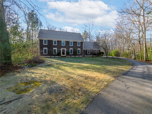 colonial inspired home featuring a front lawn