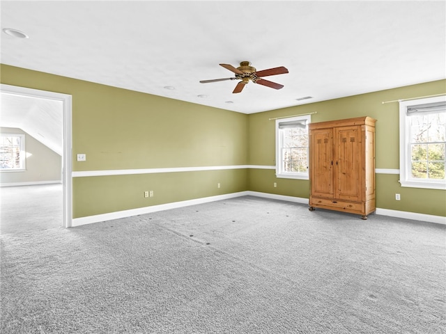 spare room featuring vaulted ceiling, ceiling fan, and carpet