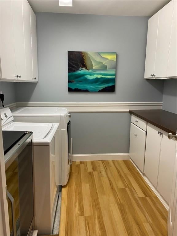 laundry room featuring cabinets, light hardwood / wood-style flooring, and independent washer and dryer