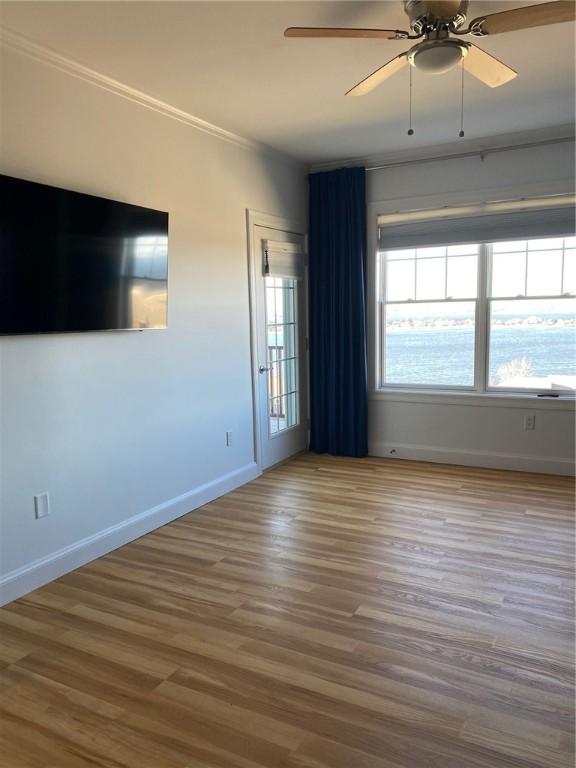 unfurnished room with ceiling fan, wood-type flooring, and crown molding