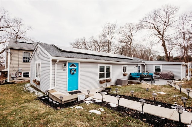 view of front of home featuring solar panels, a front yard, outdoor lounge area, and a patio