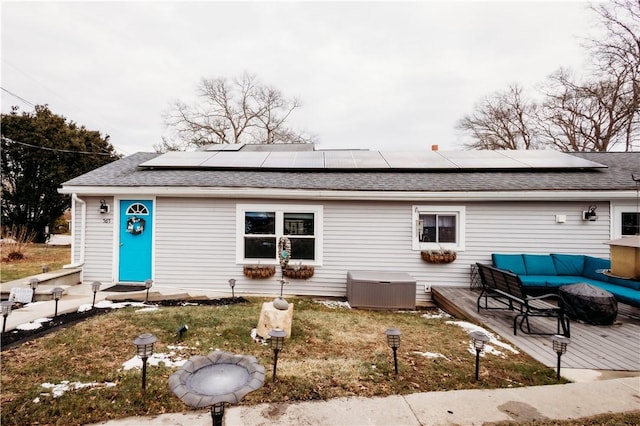 view of front of house featuring a deck, solar panels, and an outdoor living space