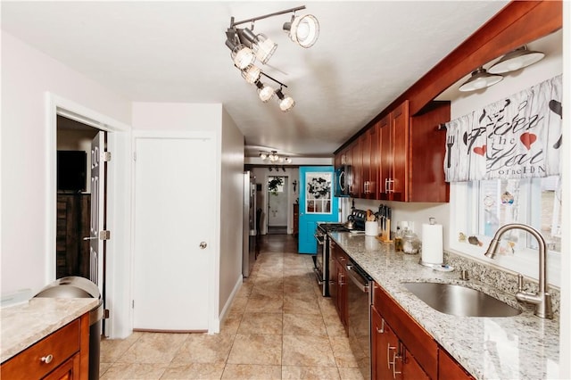 kitchen with light stone counters, stainless steel appliances, ceiling fan, and sink