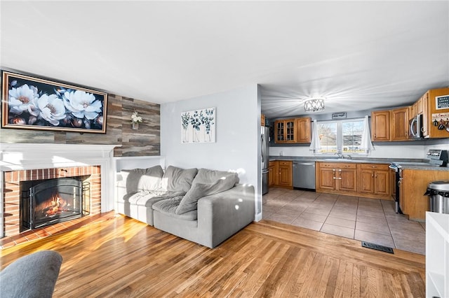 living room featuring light hardwood / wood-style floors, sink, and a fireplace