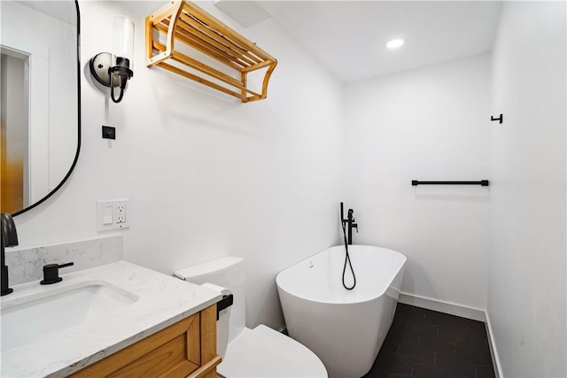 bathroom with a tub, toilet, vanity, and tile patterned flooring