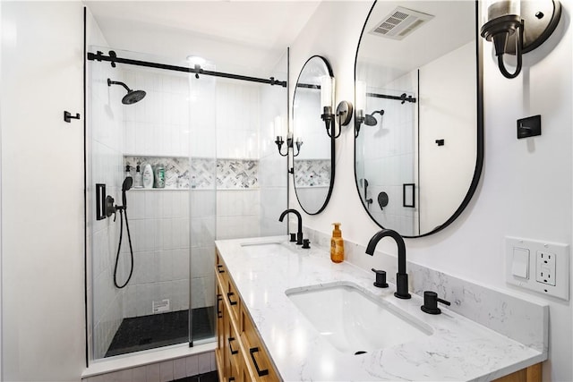 bathroom with a shower with shower door and vanity