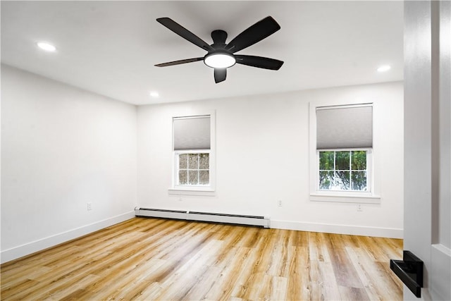 empty room featuring ceiling fan, light wood-type flooring, and a baseboard radiator