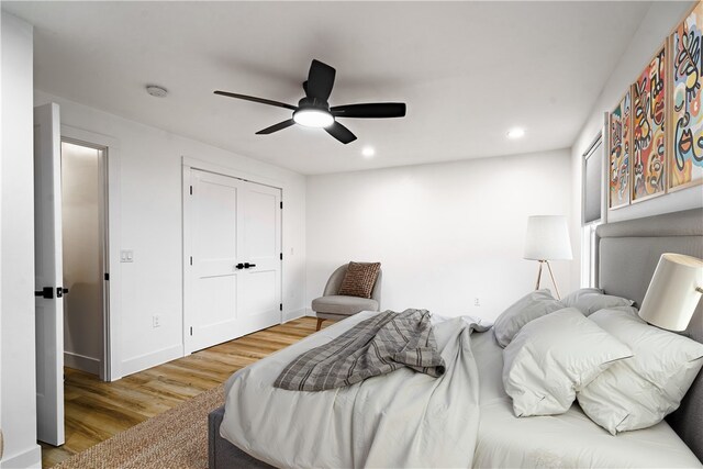 bedroom with ceiling fan, a closet, and light hardwood / wood-style flooring