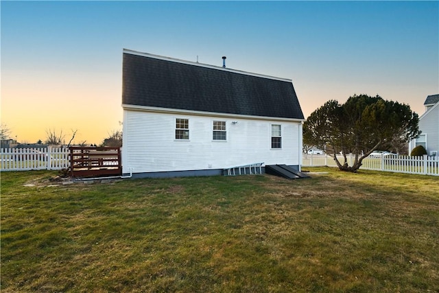 back house at dusk with a yard