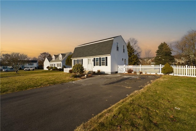 cape cod house with a lawn