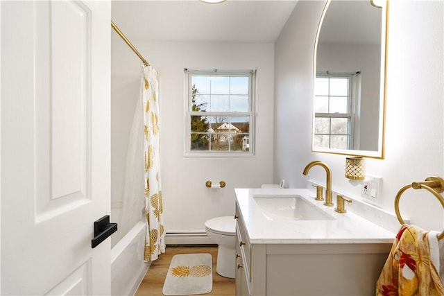 full bathroom featuring hardwood / wood-style floors, a baseboard heating unit, vanity, shower / tub combo, and toilet