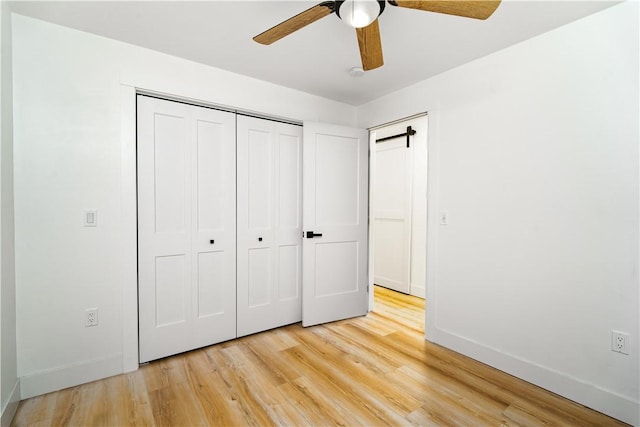 unfurnished bedroom with ceiling fan, a closet, and light wood-type flooring